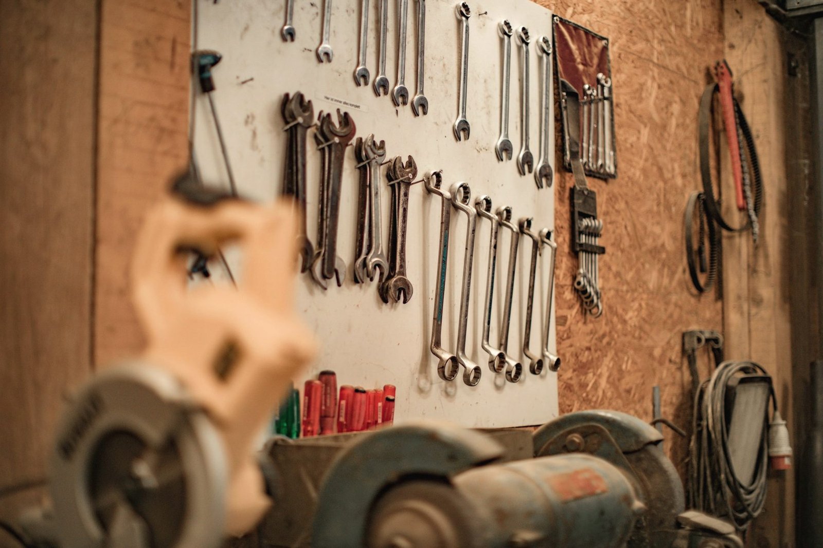 Wrenches hanging in rows on a workshop pegboard